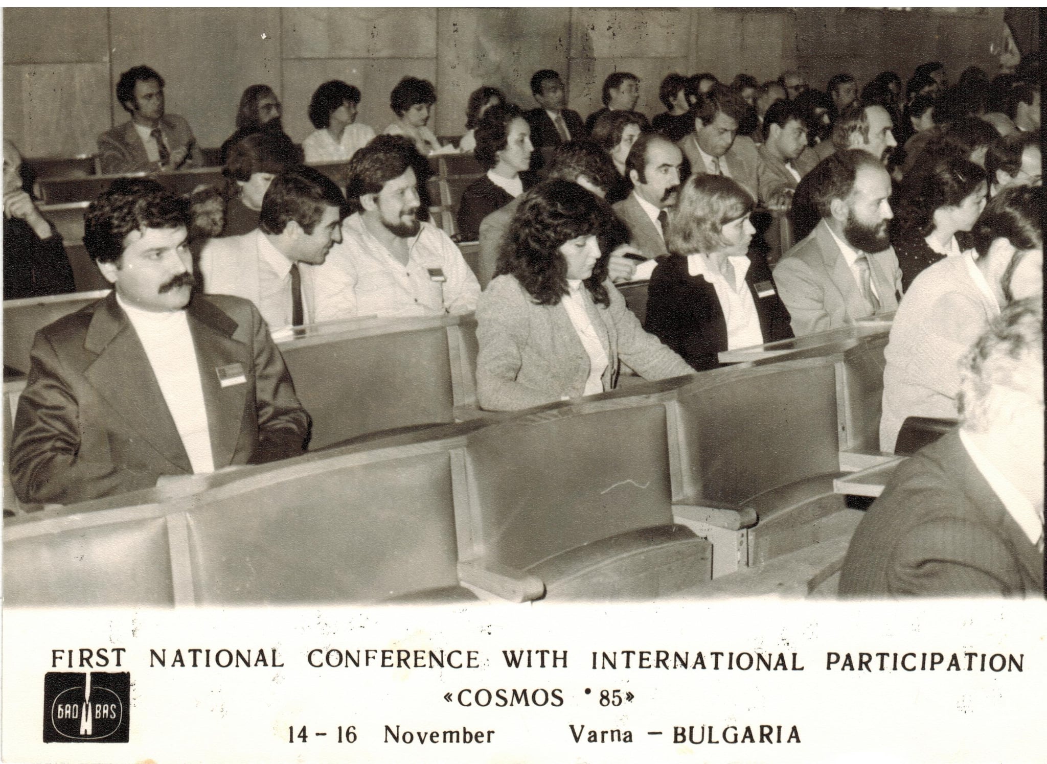 Black-and-white archival photograph of participants seated in a lecture hall at Cosmos ’85 in Varna, Bulgaria.